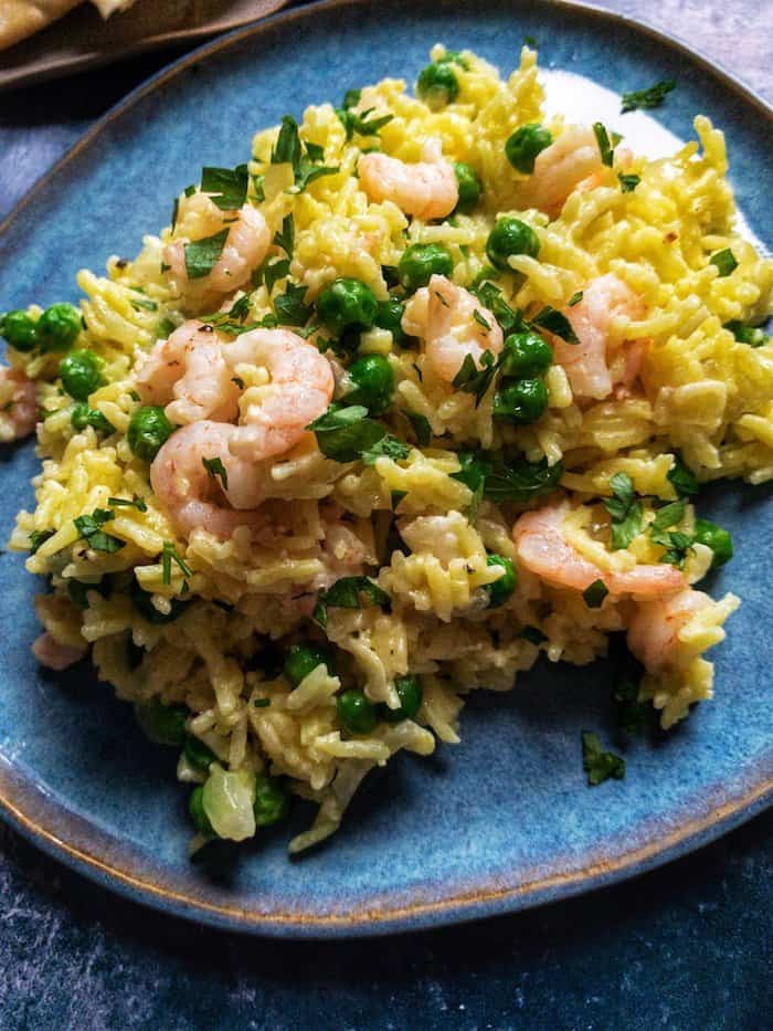Rice mixed with prawns and peas and garnished with chopped herbs. 