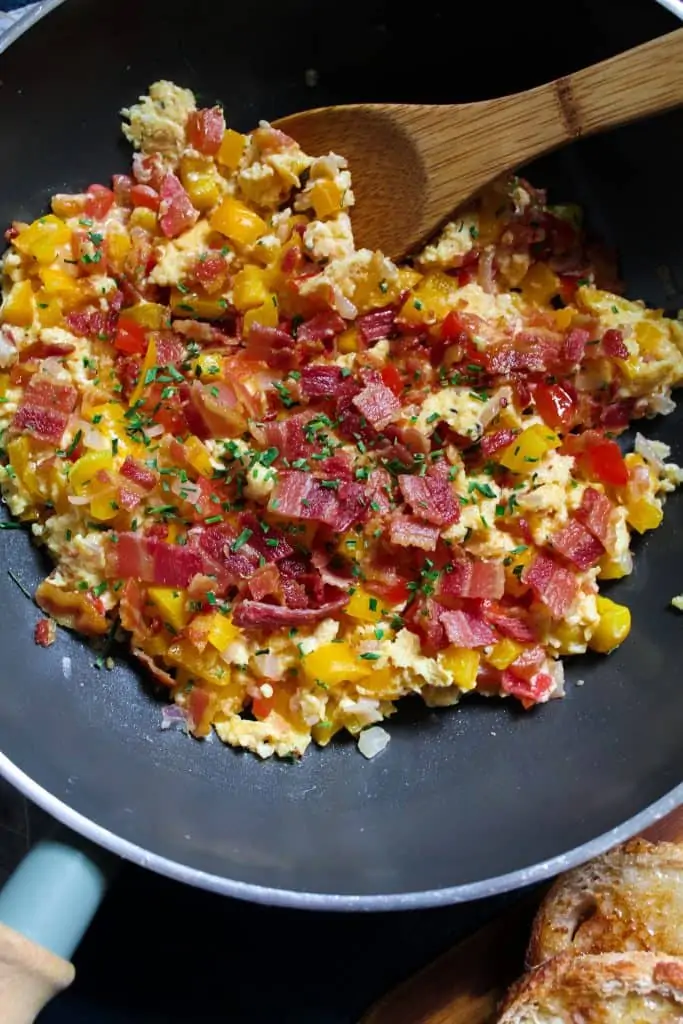 An easy and healthy way to upgrade your scrambled eggs - peppers, tomatoes, cheese, bacon and a sprinkle of chilli make these Fiesta Scrambled Eggs a party on your plate.