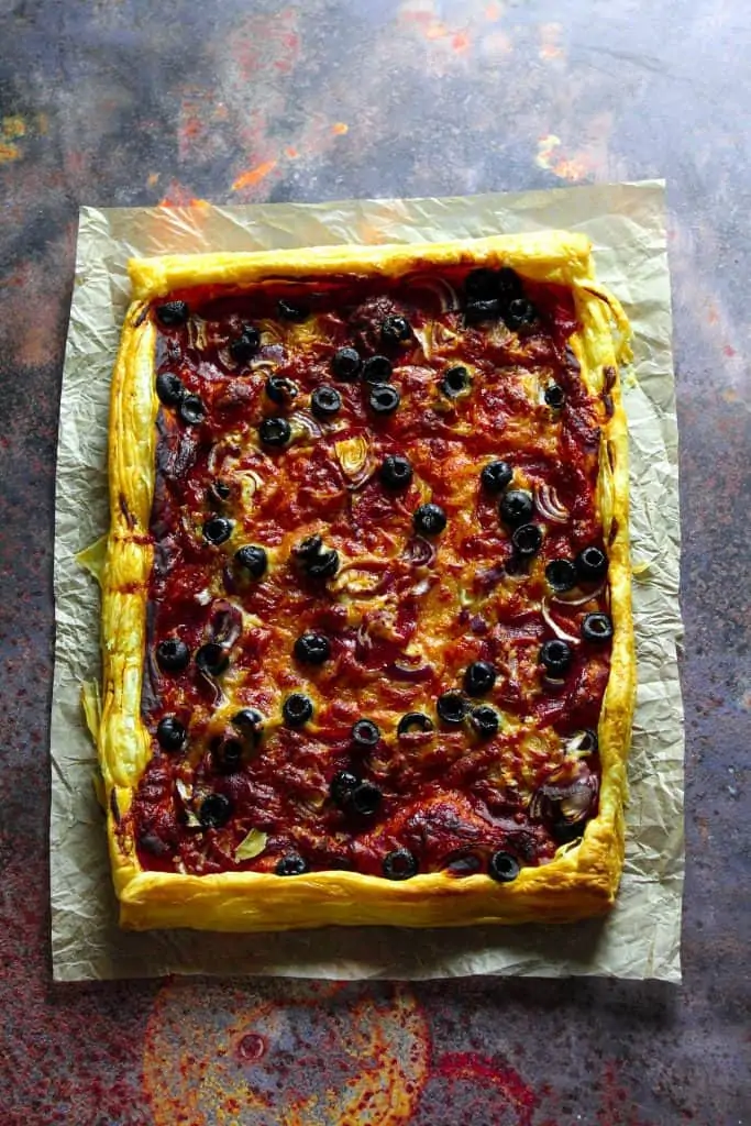 puff pastry pizza with pepperoni, olives, red onion