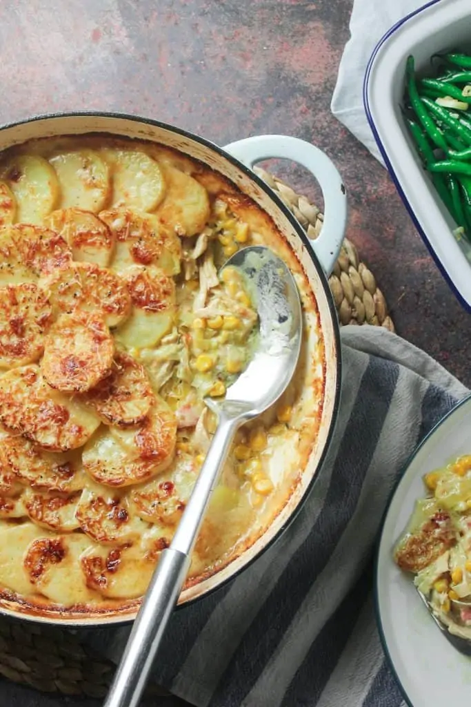 Chicken, sweetcorn and potato gratin in a shallow casserole dish with a side of steamed green beans. 
