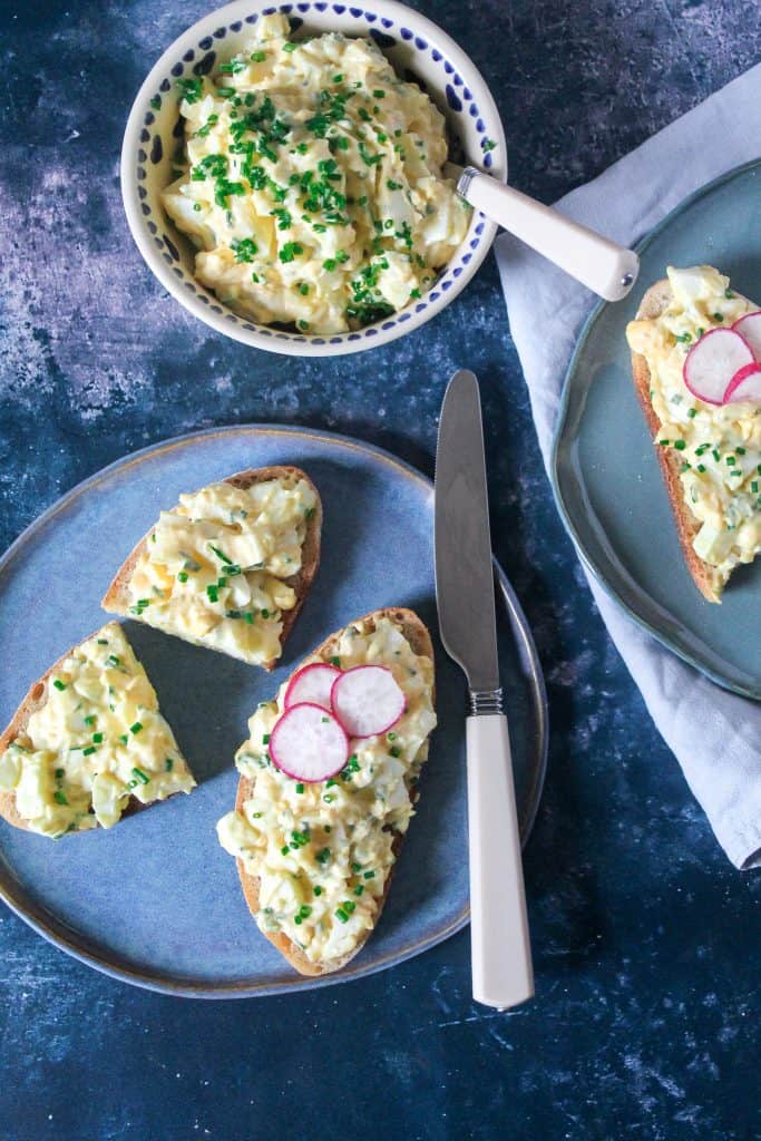 egg salad on a slice of sourdough toast, garnished with sliced radish