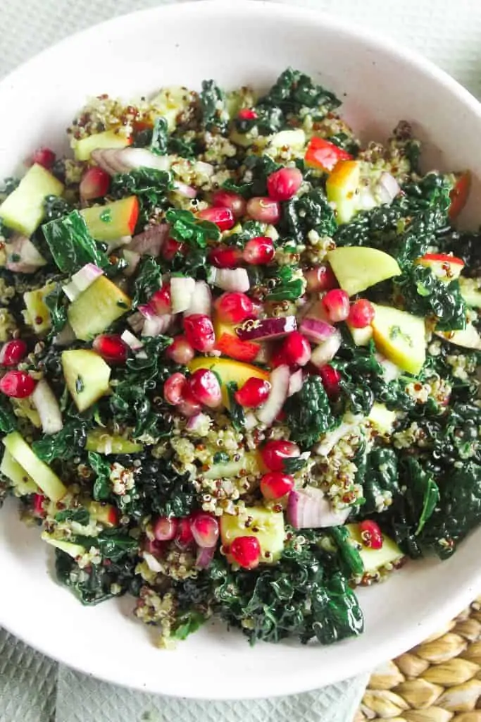 Close up of a salad made with kale, pomegranate, apple, red onion and quinoa. 