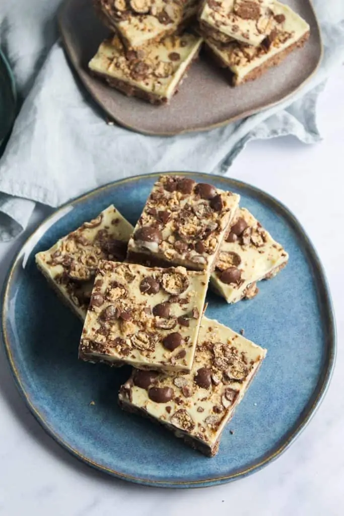 Square pieces of malteser slice traybake decortaed with white chocolate and crushed maltesers. 