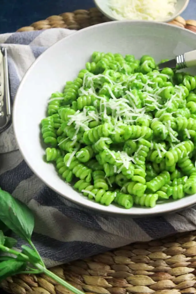 Pasta spirals coated in a green spinach pesto sauce. 