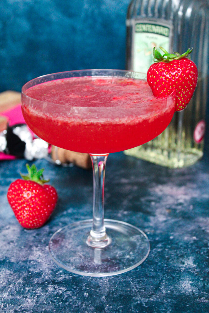 Pink strawberry, tequila and sparkling wine cocktail in a coupe glass.