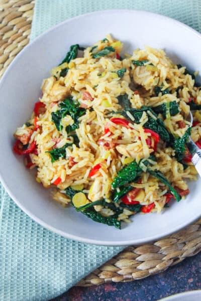 Bowl of rice stir fried with chicken, chorizo, leeks, red pepper and kale.