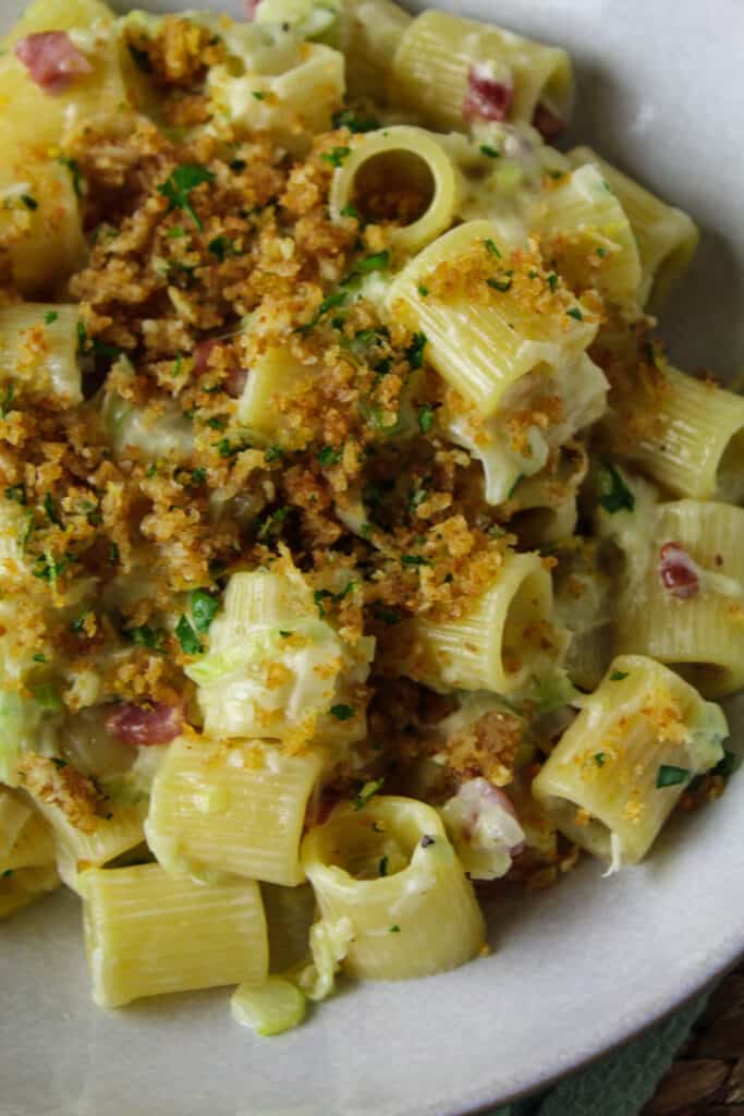 Close up of creamy leek and pancetta pasta topped with herb breadcrumbs.