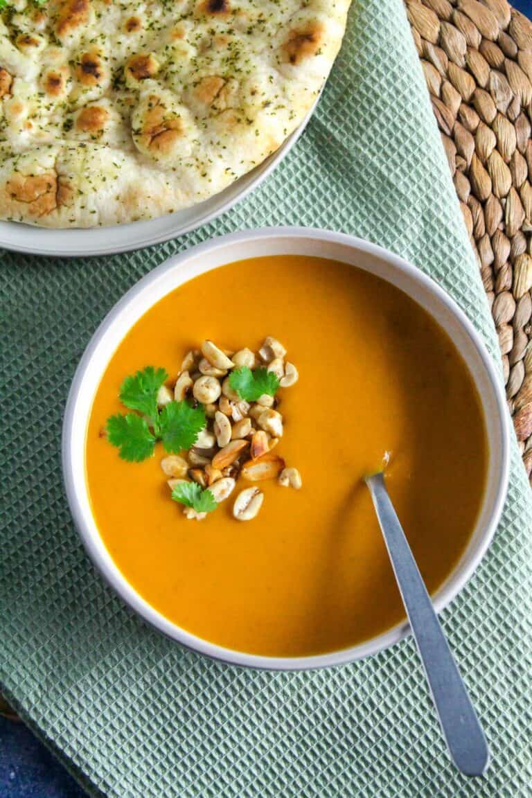 Bowl of Thai Sweet Potato and Carrot Soup topped with toasted peanuts and coriander.