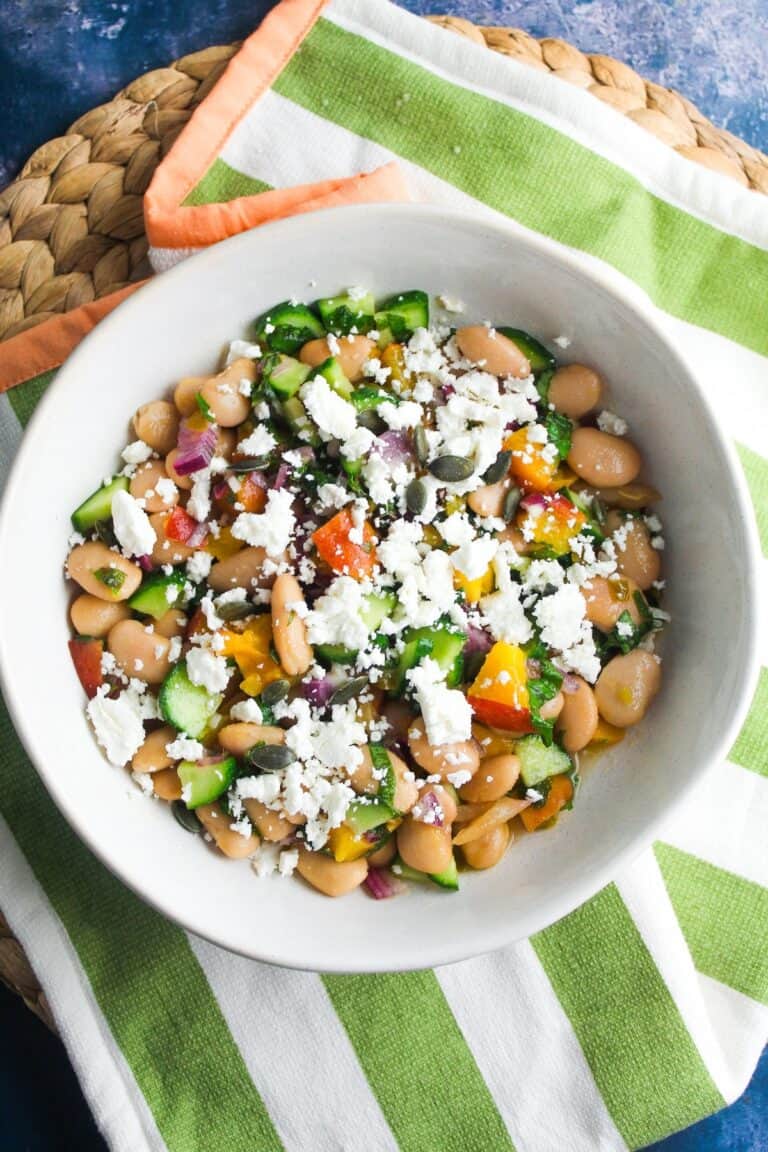 Peach and bean salad in a white bowl.