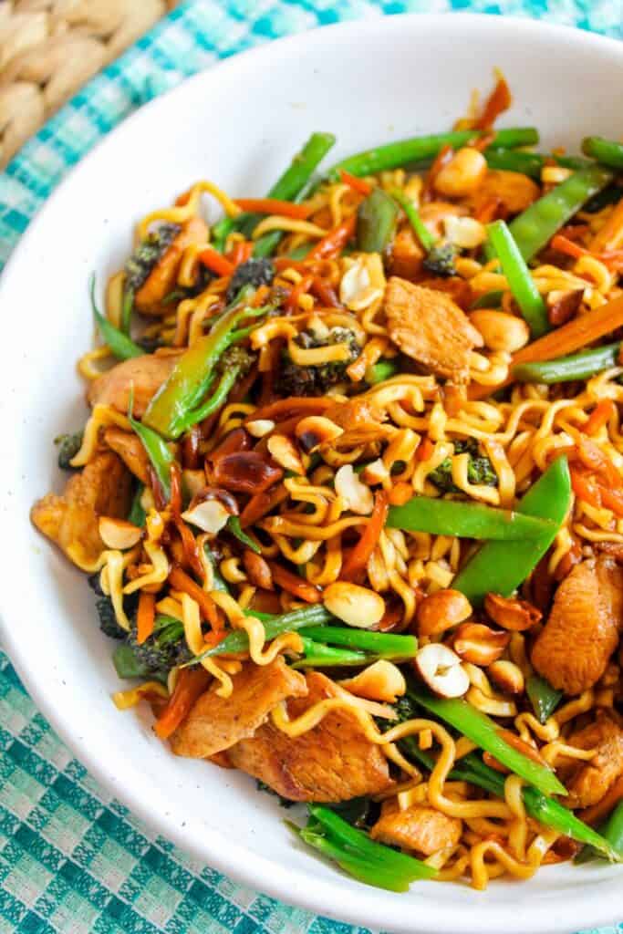 Stir-fried vegetable and noodle dish with chicken, broccoli, bell peppers, and peanuts.