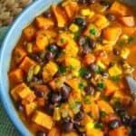 Sweet potato and black bean soup with corn and herbs, hearty and nutritious comfort food.