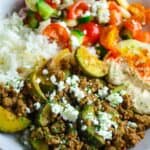 Delicious ground beef with zucchini, served with fresh salad and hummus.