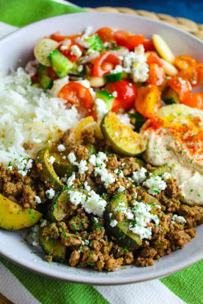 Delicious ground beef with zucchini, served with fresh salad and hummus.