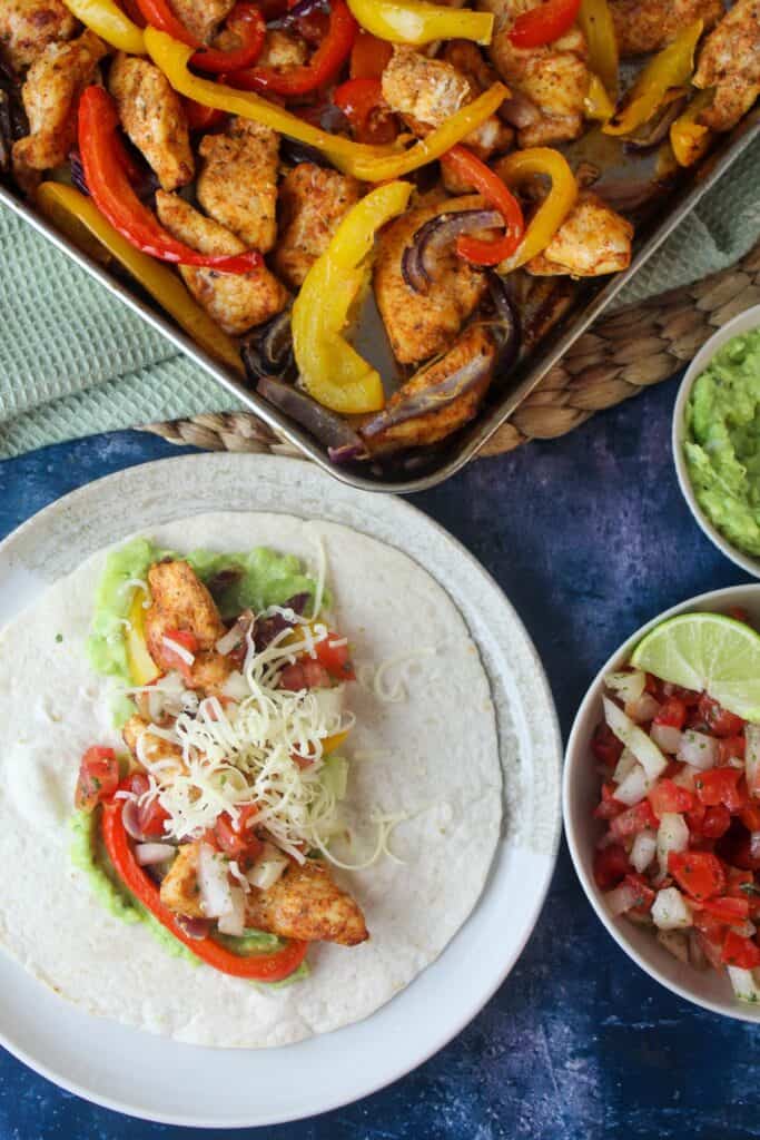Delicious chicken fajitas with peppers and onions, served with fresh salsa and guacamole.